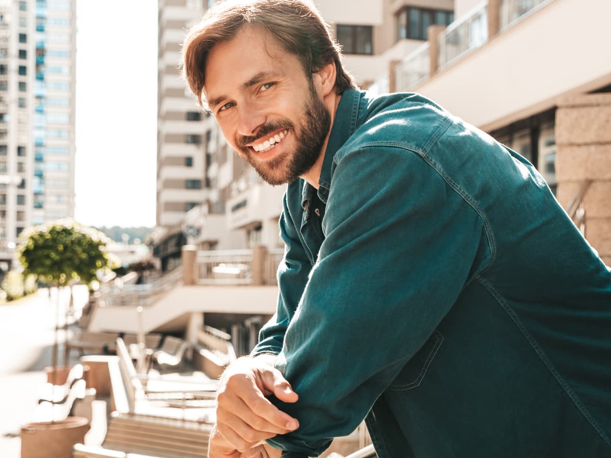 Picture of a confident man smiling outdoors